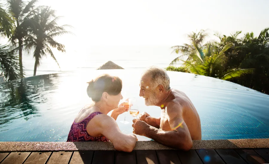 A couple relaxing in an infinity pool at sunset