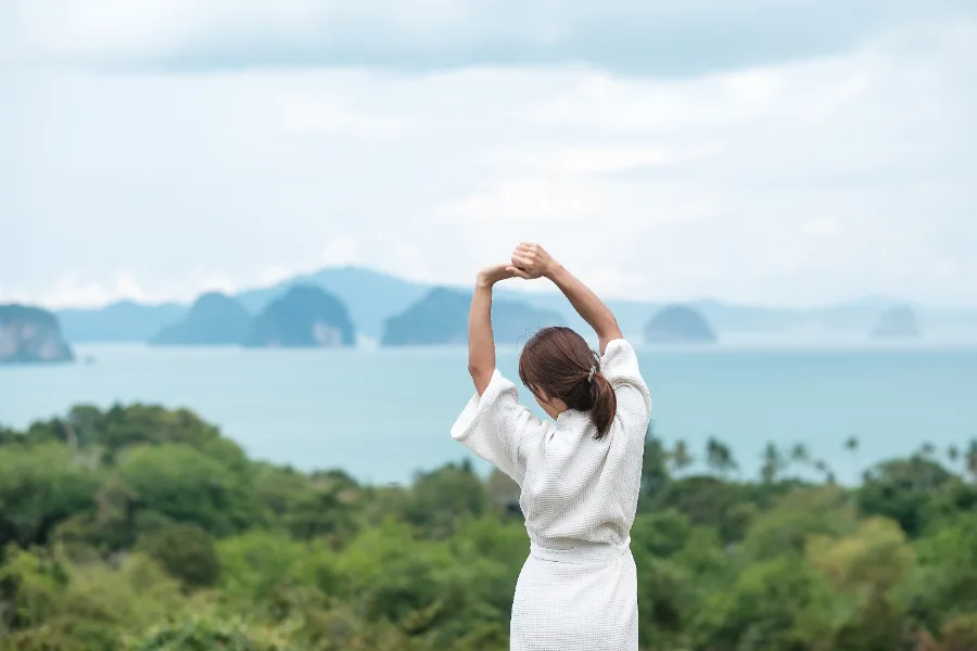 A woman stretching on a terrace above the sea
